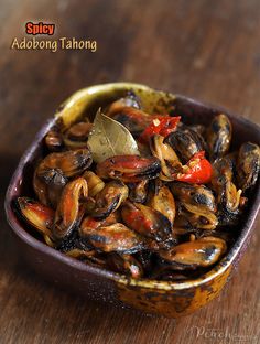 a bowl filled with mussels on top of a wooden table