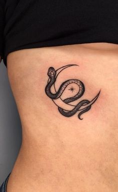 a woman's stomach with a snake tattoo on the side and an arrow in the middle