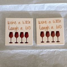 two coasters that have wine glasses on them