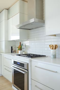 a kitchen with white cabinets and stainless steel appliances