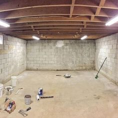 an unfinished room with several buckets and tools on the floor in front of it