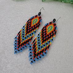 a pair of beaded earrings sitting on top of a table