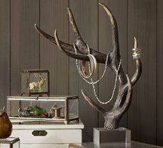 a living room filled with furniture and a metal sculpture on top of a glass table