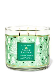 a green candle with white pine trees on it