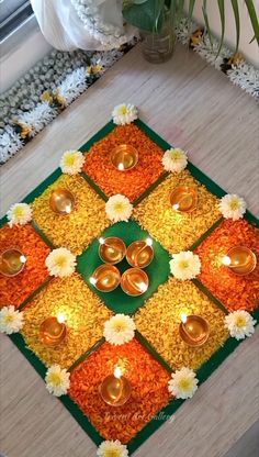 an arrangement of flowers and candles on the floor