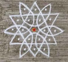 an artistic drawing on wood with white lines and red dot in the center, which looks like a flower