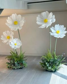 three vases with flowers in them sitting on a table