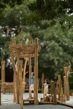 two children playing on a wooden play set