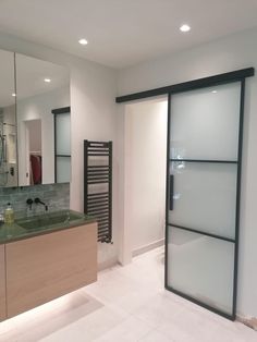 a bathroom with a sink, mirror and sliding glass door