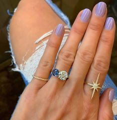 a woman's hand with two rings on it and one ring has a starfish