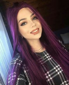 a woman with long purple hair is smiling for the camera while wearing a black and white sweater