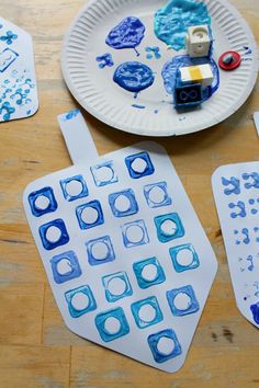 paper plates with blue and white designs are on a table next to crafting supplies