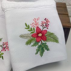 two white towels with red and green flowers on them