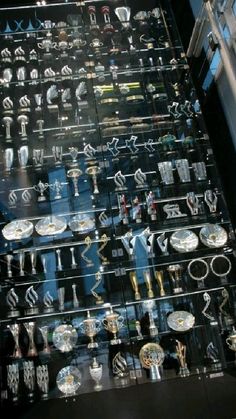 a display case filled with lots of different types of glassware and silver wares