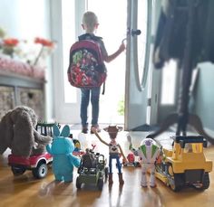 a little boy standing in front of a bunch of toys