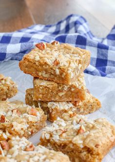 several pieces of oatmeal bars stacked on top of each other in front of a blue and white checkered napkin