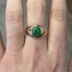 This Mid-Century cocktail ring features a cabochon cut natural green jade in 14k rose gold. The stone has a marvelous, tropical green hue set in glowing 14k rose gold. Reaching 5.48mm above the finger and weighing 4.9 grams, this Mid-Century statement cocktail ring is an outstanding piece of vintage jewelry! Composition: 14 Karat Rose Gold Ring Size: 10.5 Primary Stone: Green Jade Shape and Measurements: 9.41mm x 8.50mm General Characteristics: Height Above Finger: 5.48mm Measurements: 13.18mm T Green Cabochon Emerald Ring Fine Jewelry, Fine Jewelry Green Cabochon Emerald Ring, Fine Jewelry Green Emerald Cabochon Ring, Green Oval Cabochon Emerald Ring, Fine Jewelry Emerald Green Oval Cabochon Ring, Green Emerald Ring With Oval Cabochon Bezel Setting, Luxury Green Rings With Bezel Setting, Luxury Green Emerald Ring With Bezel Setting, Luxury Green Ring With Bezel Setting