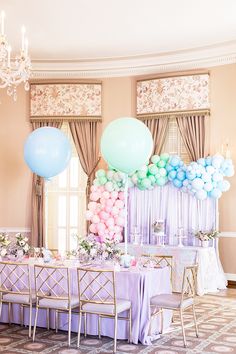 a table set up with balloons and other decorations