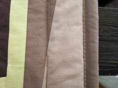 the fabric is different shades of brown, yellow and green on this piece of cloth