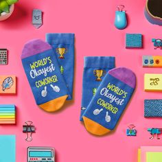 two pairs of blue socks with words on them sitting next to various office supplies and magnets