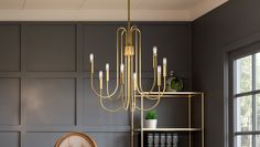 a living room with grey walls and a gold chandelier