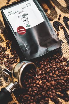 a bag of coffee sitting on top of a pile of coffee beans