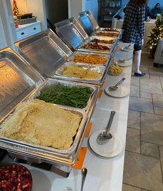 several trays of food are lined up on a table