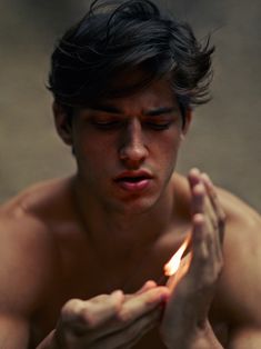 a man holding a lit candle in his hands