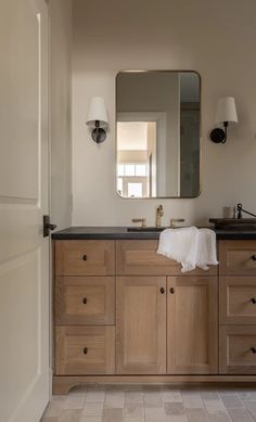 a bathroom with two sinks and a large mirror on the wall next to a door