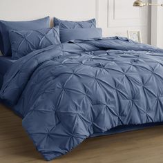 a bed with blue comforters and pillows in a room