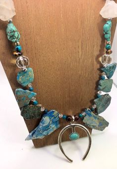 This absolutely stunning real jasper and turquoise slab crystal statement necklace is a fabulous addition to any outfit  Made with so many amazing materials crystals gemstones and silvers  This is definitely a piece to wow your friends and make a big statement  Made with ethically sourced turquoise and jasper like all of my creations  *raw turquoise  *blue real jasper  *turquoise nuggets  *red tigers eye  *African tigers eye *925 sterling silver spacers  *silver plate  *raw quartz crystal chunks Unique Turquoise Necklace With Large Stone, Unique Turquoise Crystal Necklaces For Jewelry Making, Turquoise Agate Jewelry With Large Stone, Unique Adjustable Turquoise Crystal Necklaces, Bohemian Crystal Necklace With Large Stone, Unique Turquoise Necklace With Natural Stones For Festivals, Bohemian Crystal Necklace With Large Adjustable Stone, Bohemian Chrysocolla Jewelry With Natural Stones, Bohemian Jewelry With Large Mineral Crystal Stone