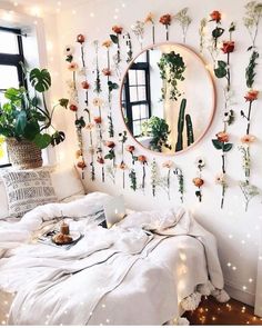 a bedroom with flowers on the wall and a bed in front of a round mirror