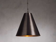 a black lamp hanging from the ceiling with an orange light on it's side