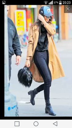 a woman is walking down the street with her hand on her head