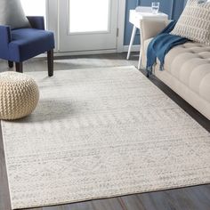 a living room with blue chairs and a white rug on the floor, in front of a couch