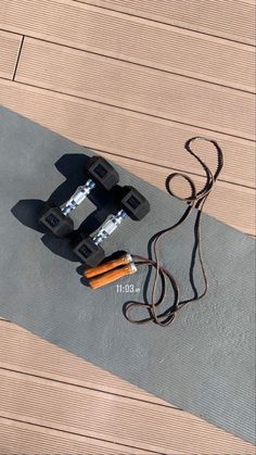 a skateboard with two batteries attached to it laying on the ground next to a cord