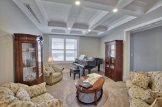 a living room filled with furniture and a piano