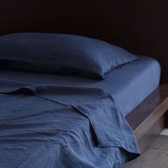 a bed with blue sheets and pillows on it