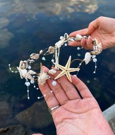 a person holding a starfish and seashells in their hand