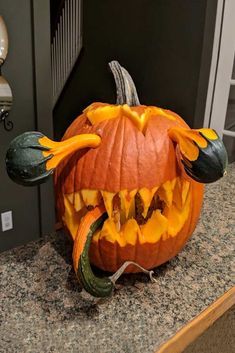 a carved pumpkin with teeth and fangs on it's head sitting on a counter