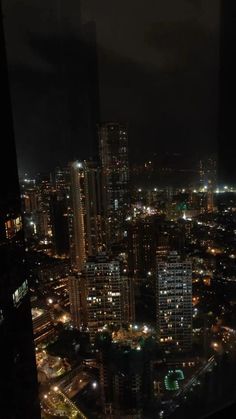 the city is lit up at night with lots of lights in the buildings and skyscrapers