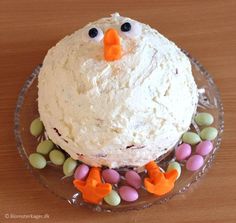 a frosted cake with carrots and candies around it