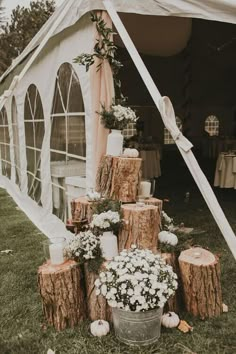 a wedding tent decorated with logs and flowers