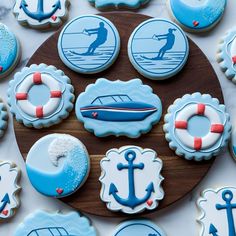 decorated cookies with blue and white frosting are arranged on a wooden platter,