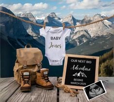 a baby's first birthday outfit, booties, and sign on a wooden table