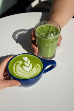 a person holding a cup of green liquid