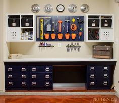 a workbench with lots of tools hanging on the wall and drawers below it