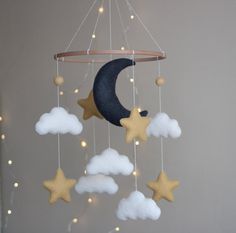 a mobile with stars, moon and clouds hanging from it