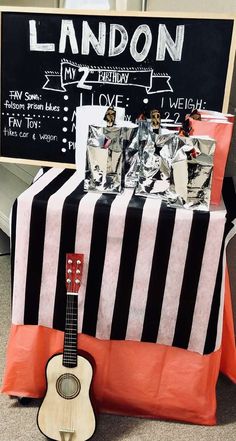 a small guitar sitting on top of a table next to a sign that says london