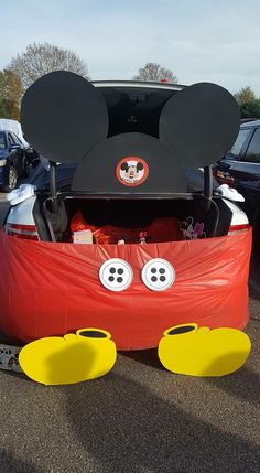 a mickey mouse car is parked in a parking lot with its hood up and ears sticking out